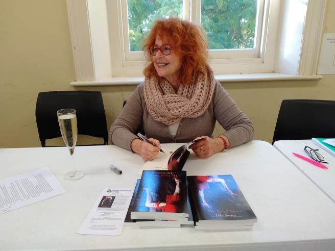 red-headed author Libby Sommer signing one of her books